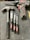 A collection of tools is arranged on a dark surface. An electric drill with the brand 'Hyper Tough' is visible alongside a claw hammer with a black handle. Three chisels of varying sizes, also branded 'Hyper Tough,' are aligned next to the hammer.