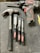 A collection of tools is arranged on a dark surface. An electric drill with the brand 'Hyper Tough' is visible alongside a claw hammer with a black handle. Three chisels of varying sizes, also branded 'Hyper Tough,' are aligned next to the hammer.