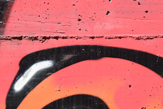 Close-up of a graffiti artist spraying paint on a textured wall.