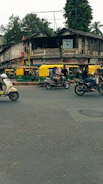A bustling city street in India with electric scooters and cars charging at a modern station.