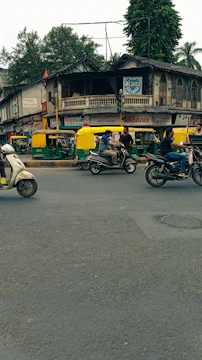 A bustling city street in India with electric scooters and cars charging at a modern station.