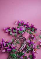 Bright and colorful bottles of women's perfumes with floral decorations around.
