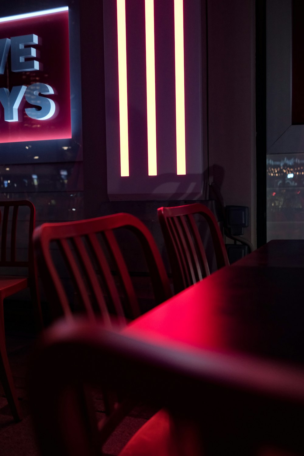 a table and chairs in a room with a neon sign