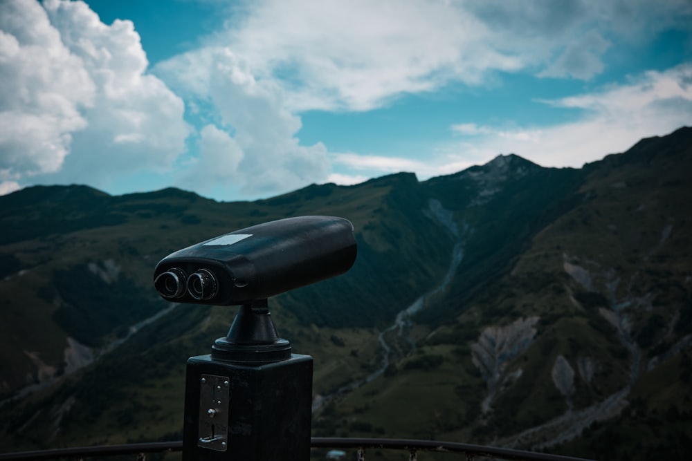 a telescope on a tripod overlooking a mountain range