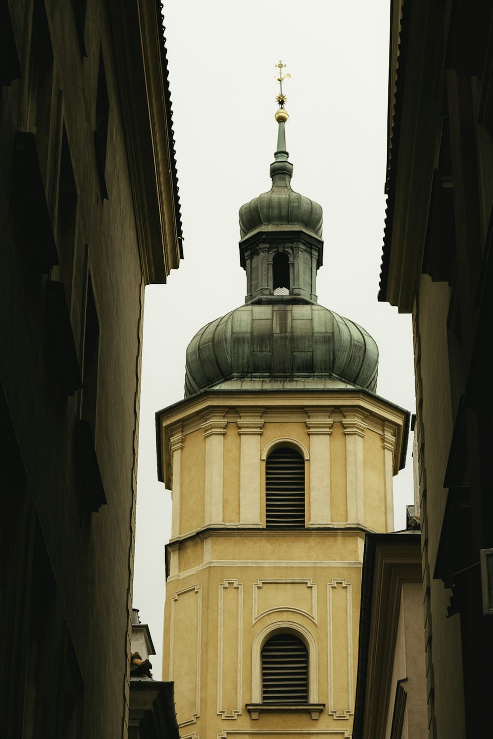 Un edificio con un campanario y una cruz en la parte superior