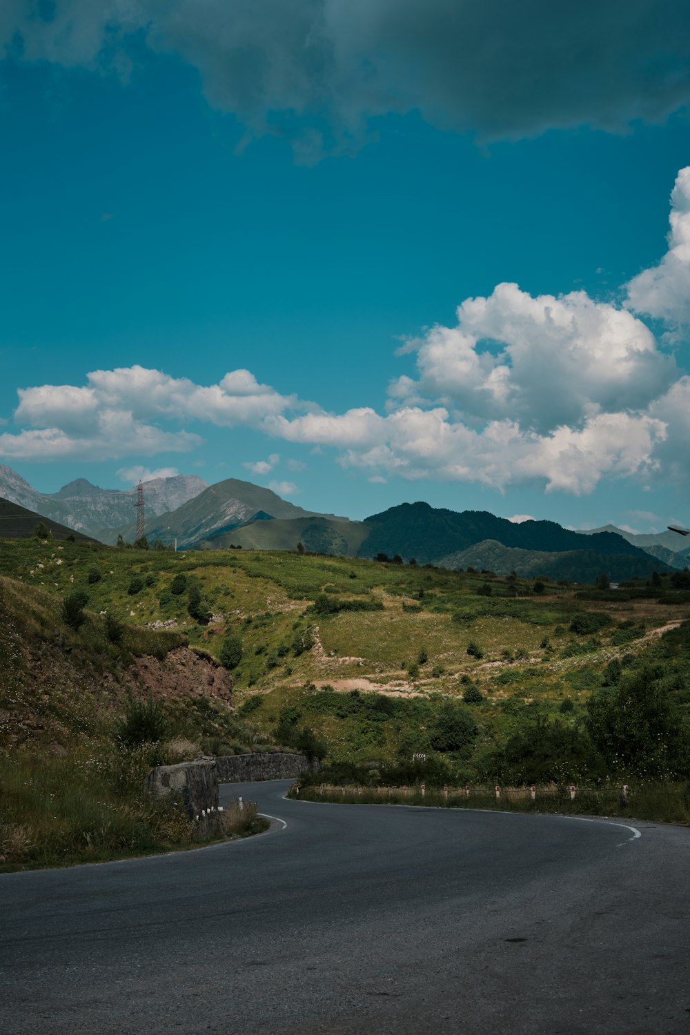 a winding road with mountains in the background