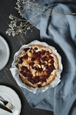 A rustic tart filled with fresh berries, set against a warm brown backdrop.