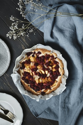 A rustic tart filled with fresh berries, set against a warm brown backdrop.