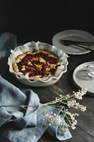 Close-up of a freshly baked fruit tart with vibrant berries on a rustic wooden table