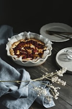 A vibrant tart with fresh fruits and a shiny glaze on a rustic wooden table.