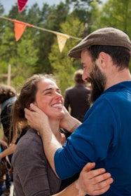 A joyful couple exchanging vows outdoors with rainbow decorations symbolizing LGBTIQ pride.