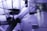 Several glass laboratory tubes and vessels with visible numbers and contents inside, possibly some kind of substance or powder. The setup appears to be part of a scientific or experimental apparatus with a bluish-purple tint dominating the scene.