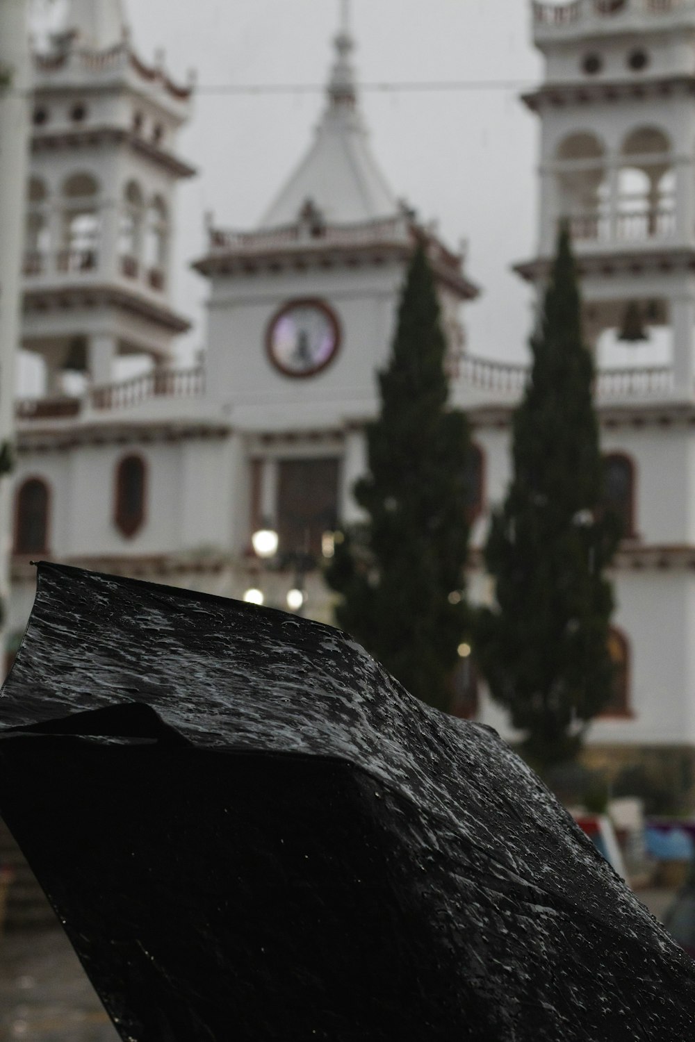 a black umbrella with a clock tower in the background