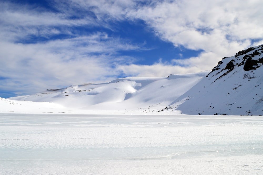 Eine verschneite Landschaft mit einem Berg im Hintergrund