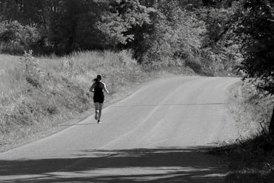 Runner wearing osseo wave headphones on a forest trail, smiling and focused.