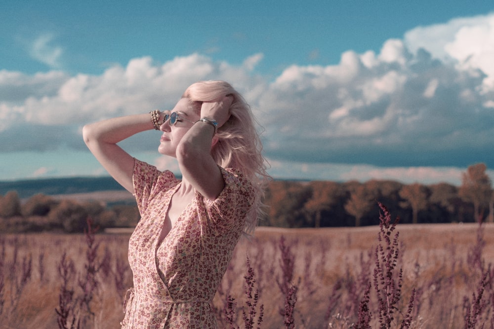 a woman standing in a field of tall grass