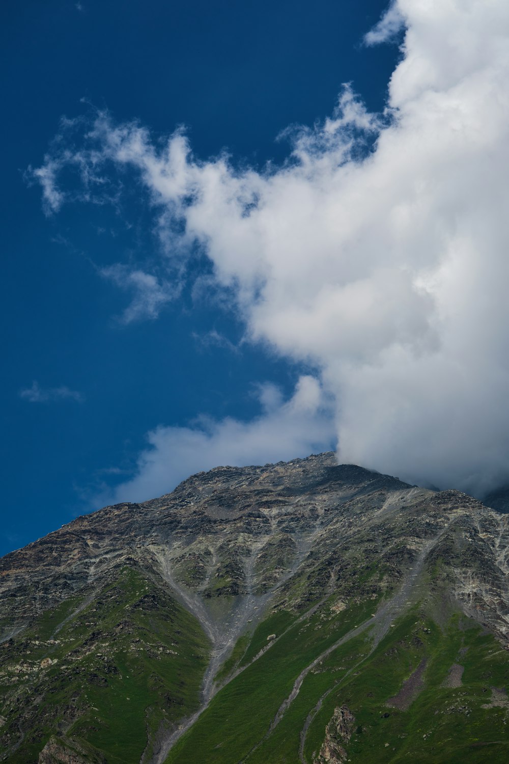 a very tall mountain with a cloud in the sky