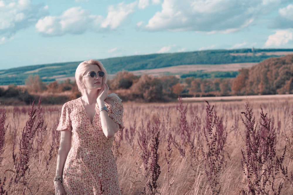 a woman standing in a field of tall grass