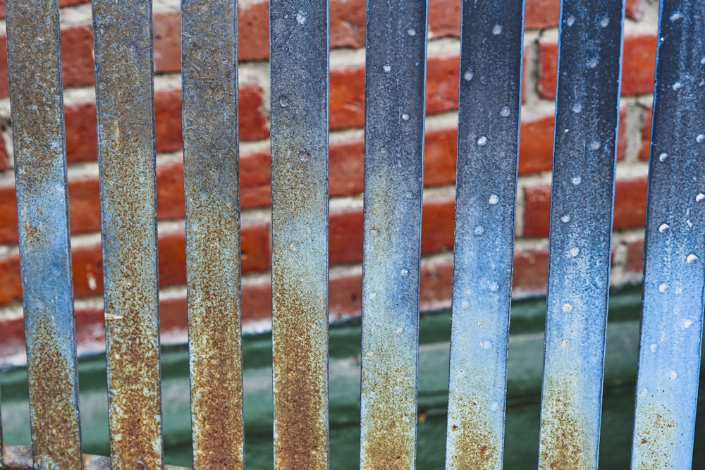 a close up of a metal fence with rust on it
