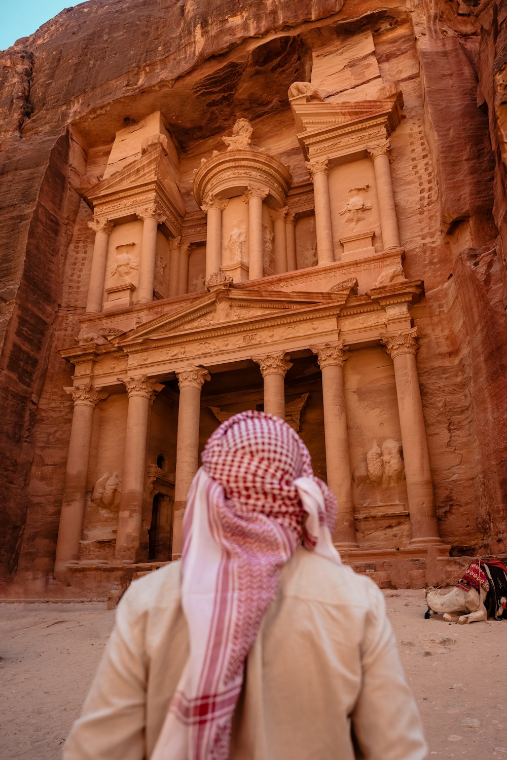 a person standing in front of a building in the desert