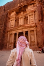 a person wearing a red and white scarf standing in front of a building