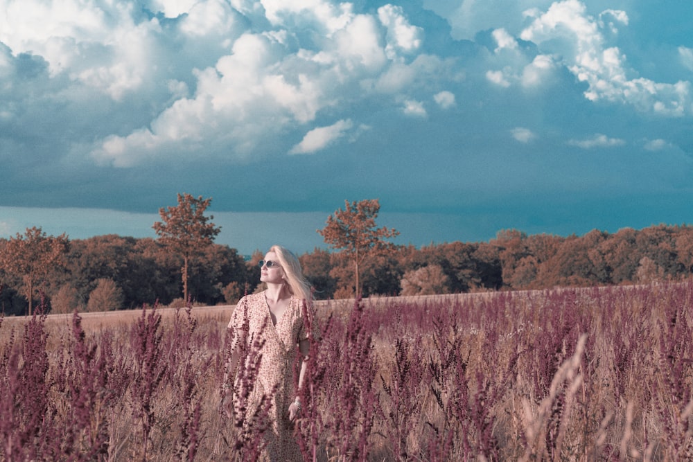 a woman standing in a field of tall grass