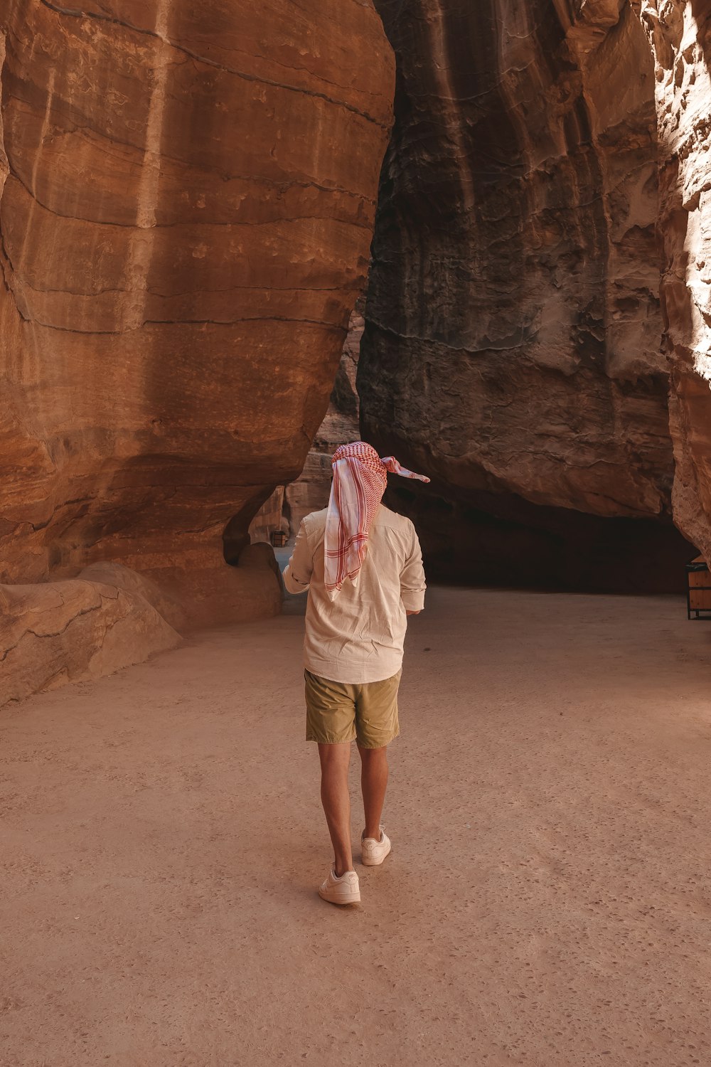 a person walking through a narrow slot in a canyon