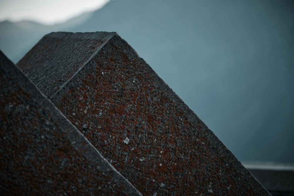 a close up of a stone structure with a mountain in the background
