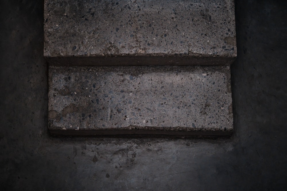 a square brick sitting on top of a cement floor