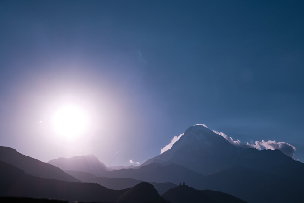 the sun shines brightly over the mountains