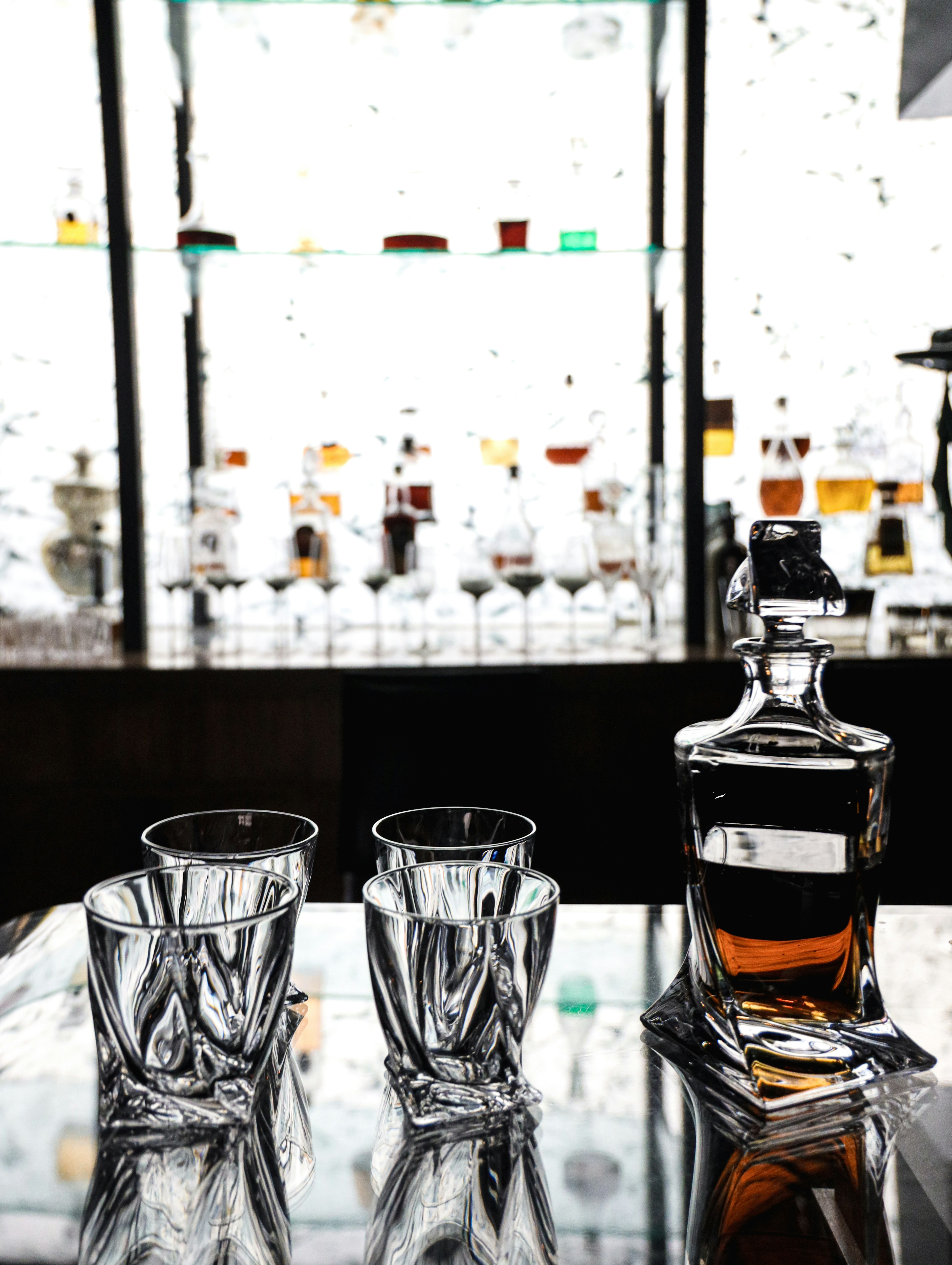 Crystal whiskey decanter set with glasses on dark background with deep moody shadows
