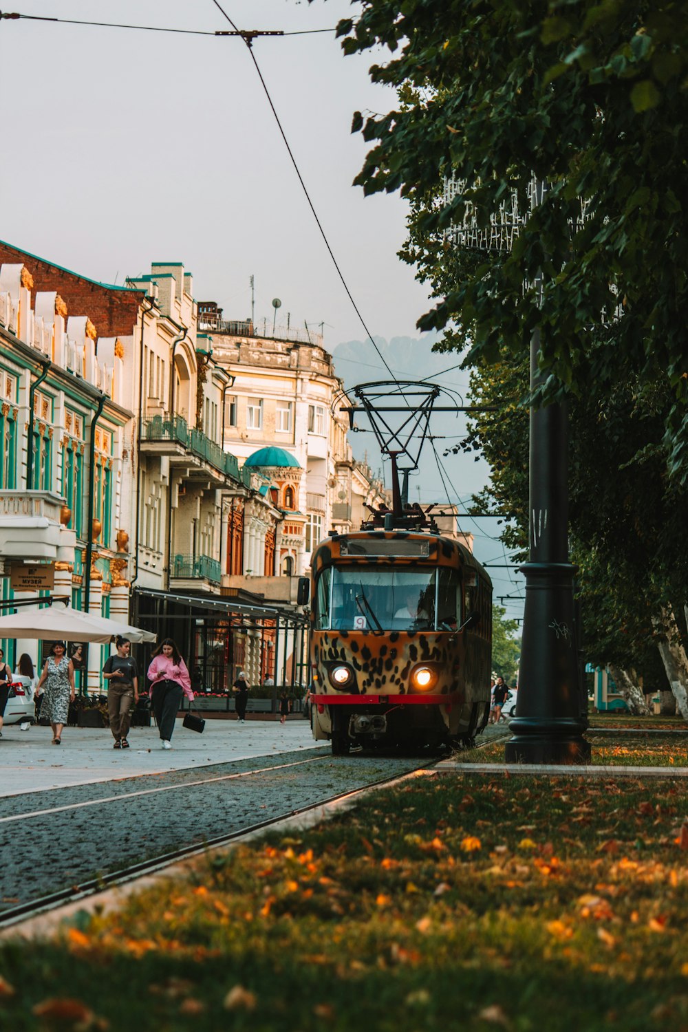 a trolley car traveling down a street next to tall buildings