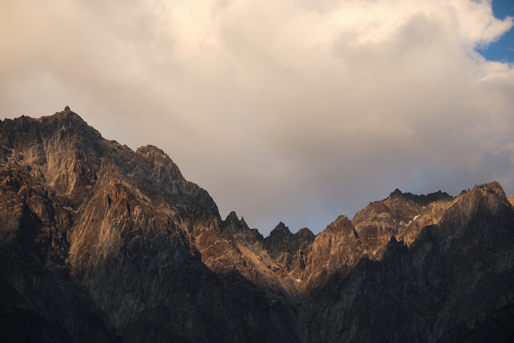 a very tall mountain with some clouds in the sky