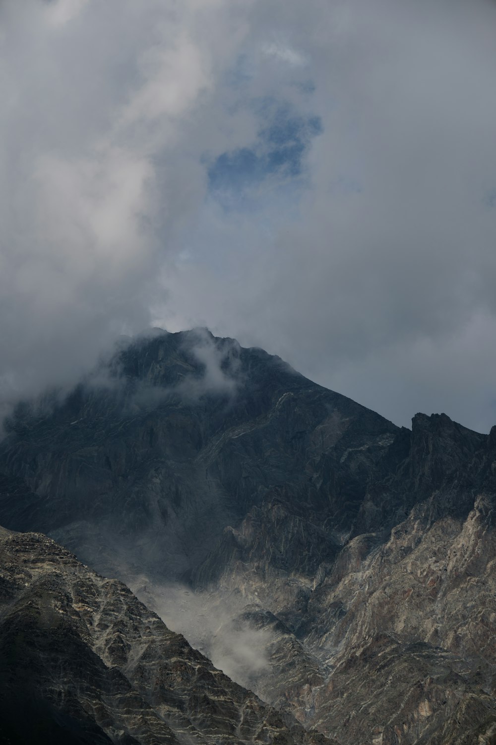 a mountain range with a few clouds in the sky