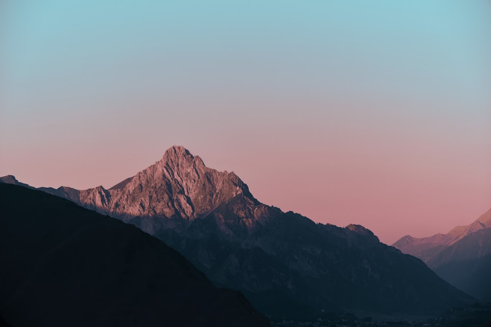 a mountain with a pink sky in the background