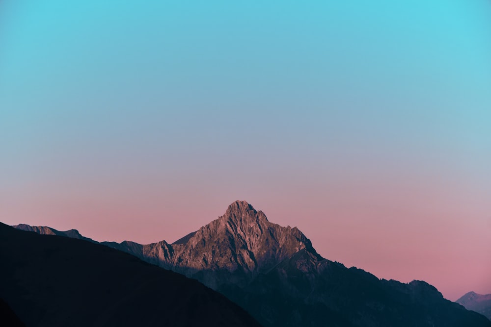 a mountain with a pink sky in the background