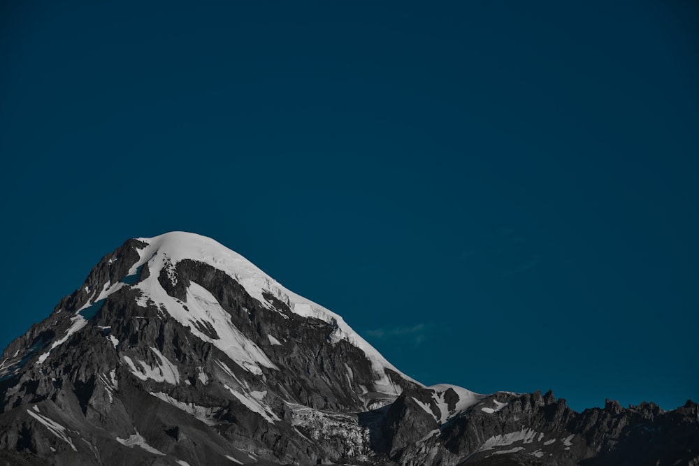 ein schneebedeckter Berg unter blauem Himmel