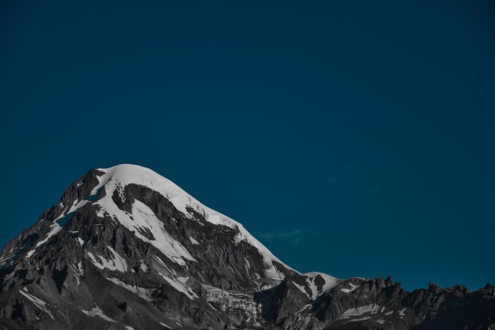 a snow covered mountain under a blue sky