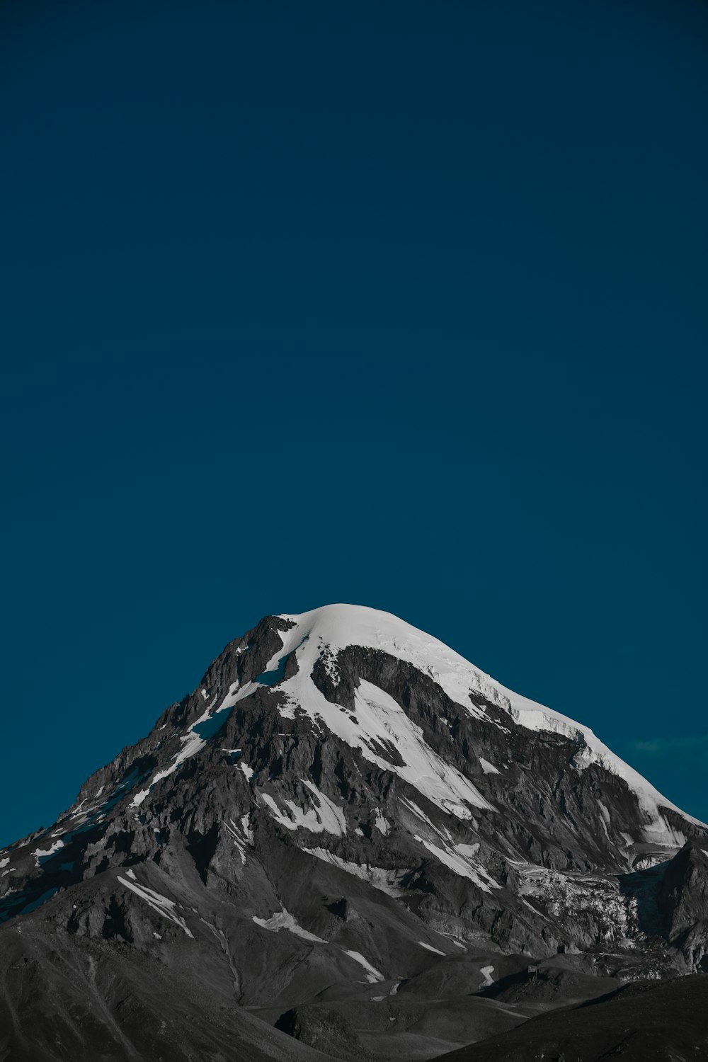 a snow covered mountain under a blue sky