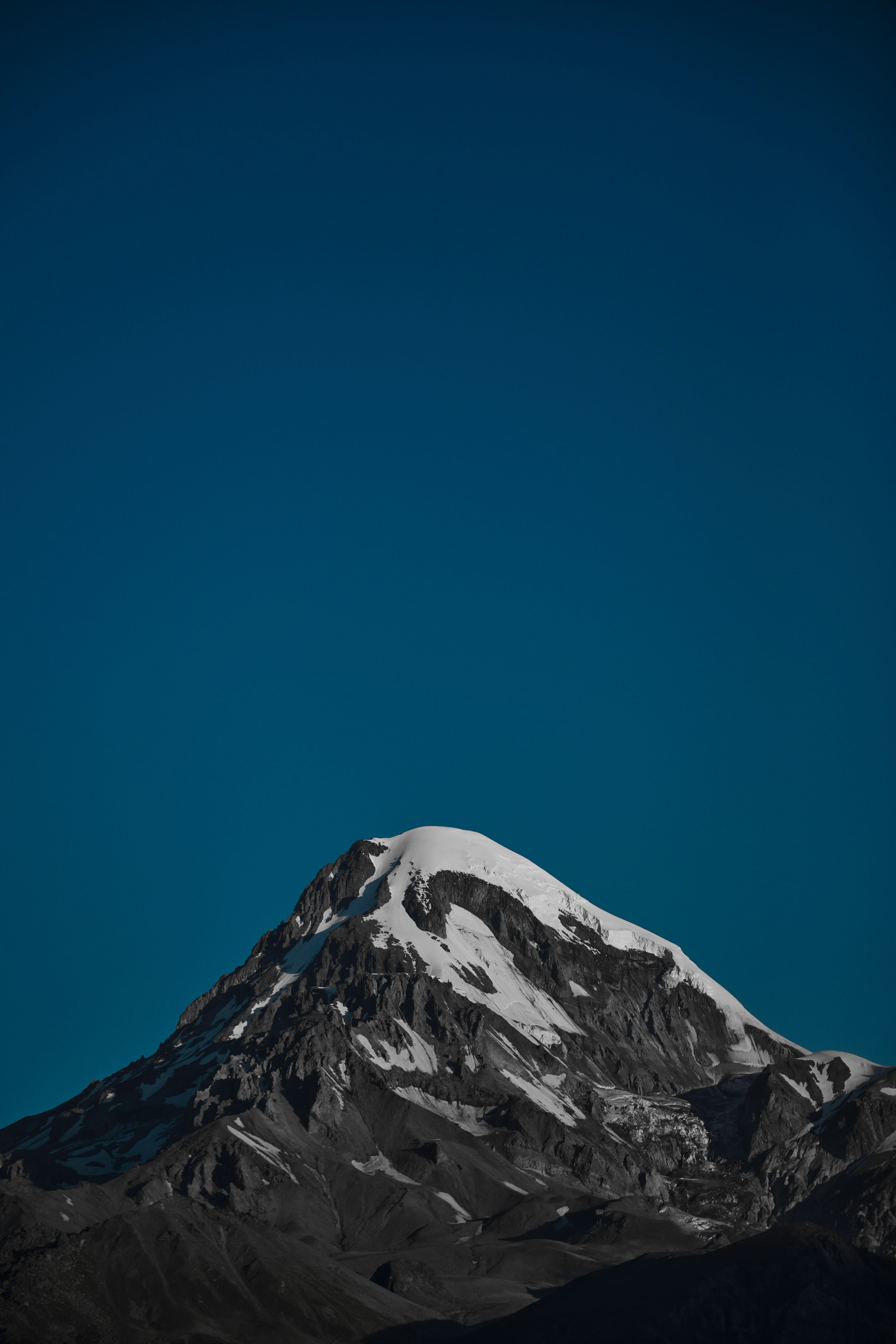 a snow covered mountain under a blue sky