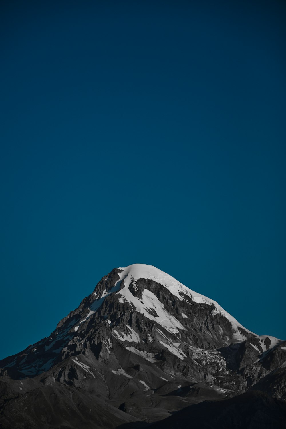 a snow covered mountain under a blue sky