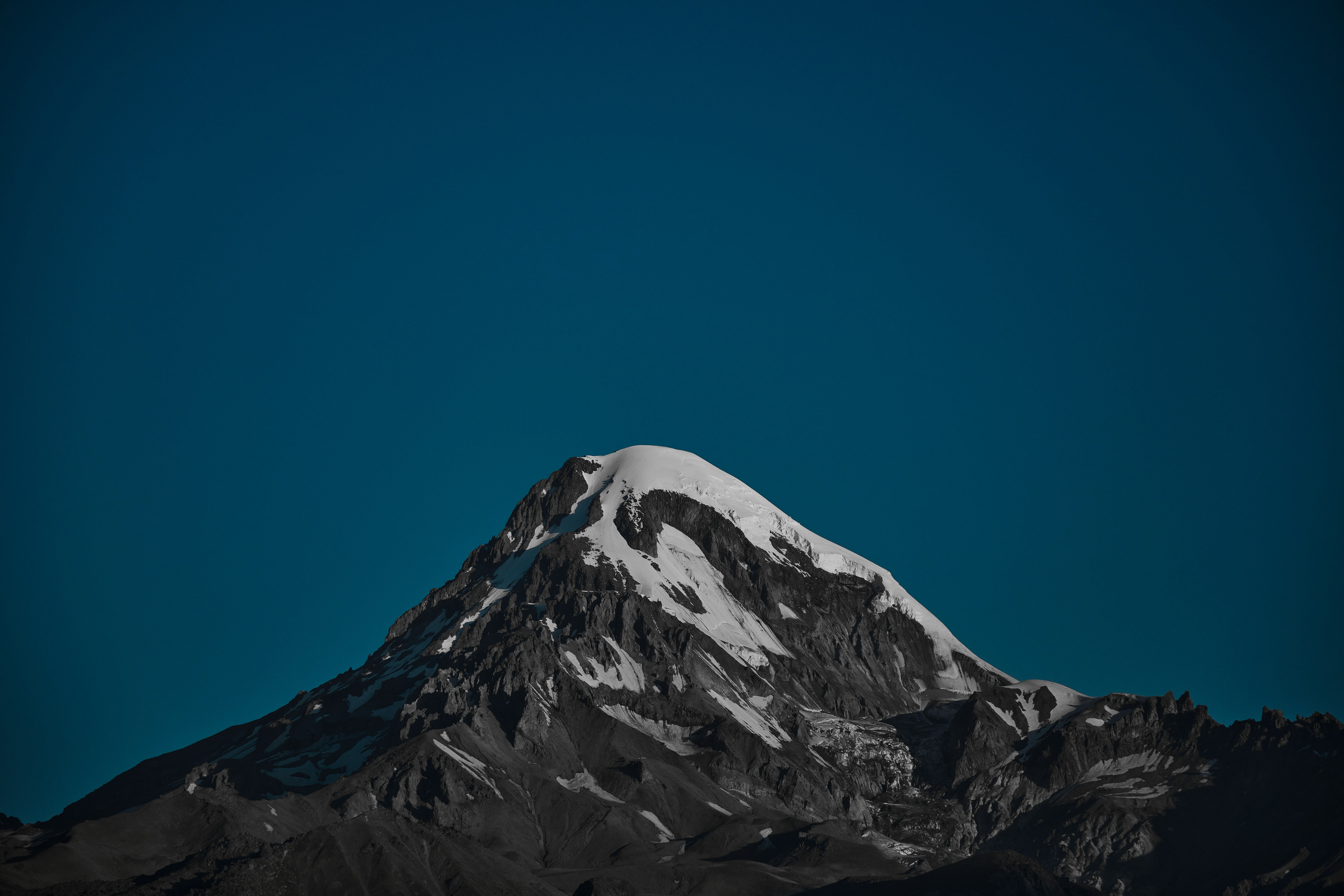 a snow covered mountain under a blue sky