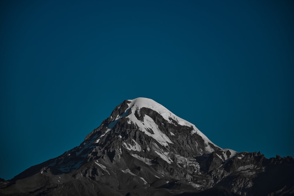 a snow covered mountain under a blue sky