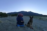 Trailguard Pack resting on a rocky outcrop with a mountain view at sunset.