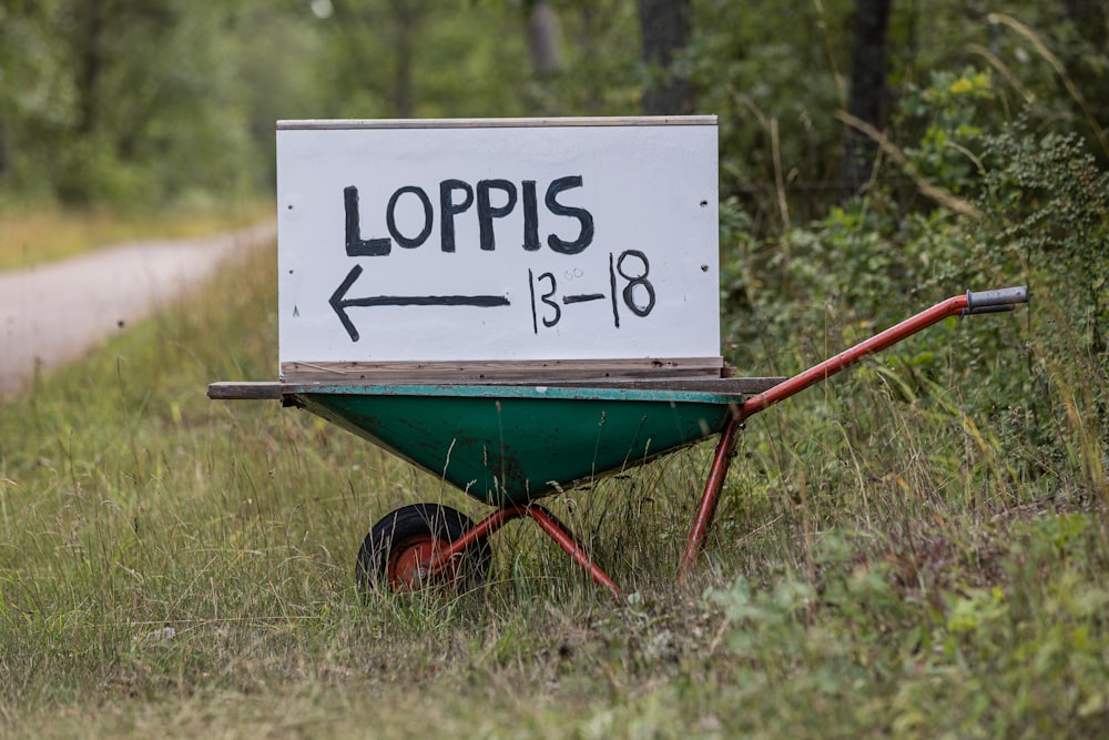 a green wheelbarrow with a sign that says lops on it