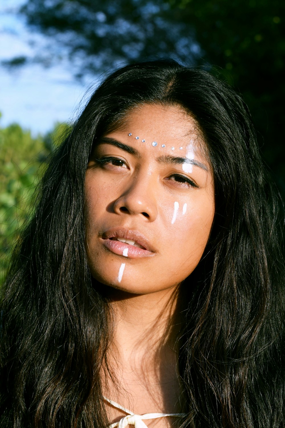 a woman with white paint on her face