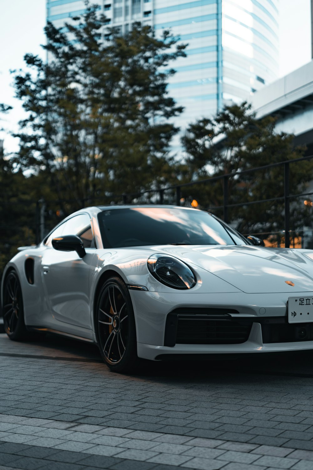 a white sports car parked in front of a tall building