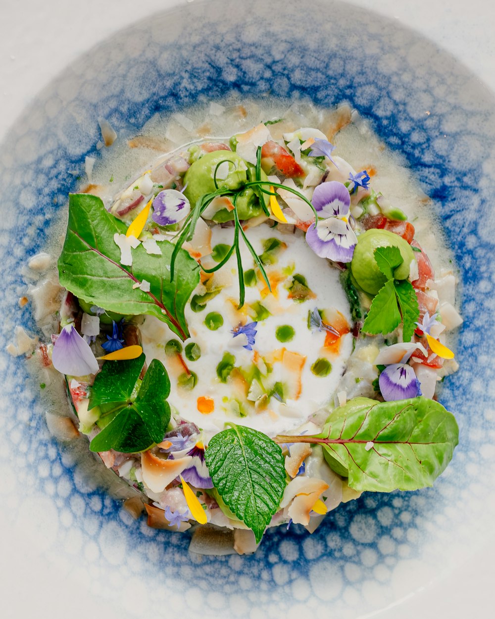 a blue and white bowl filled with food on top of a table