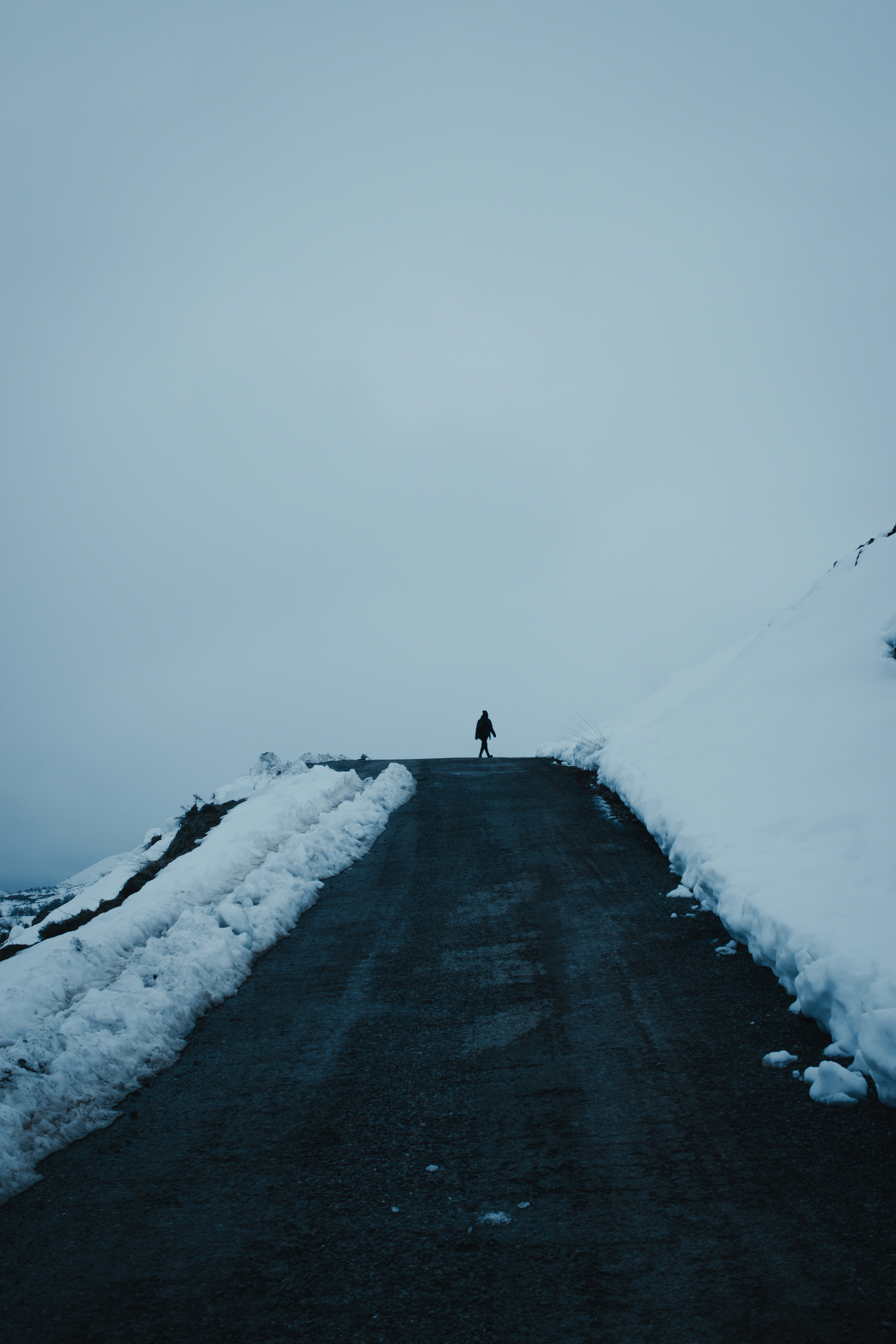 a person standing on a snow covered road