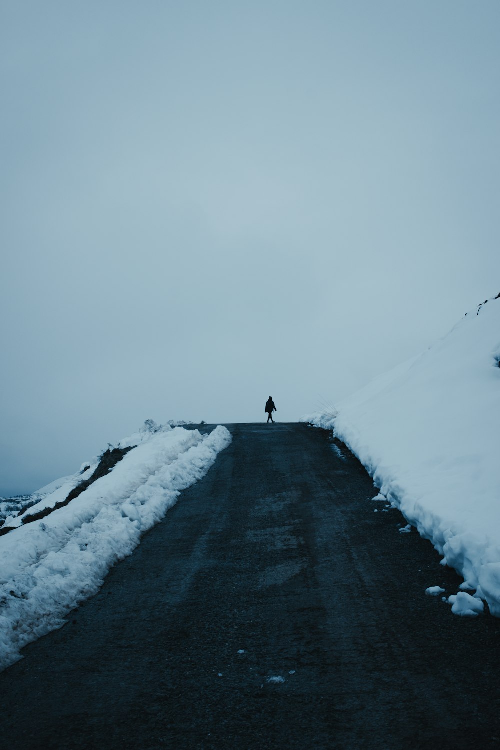 a person standing on a snow covered road